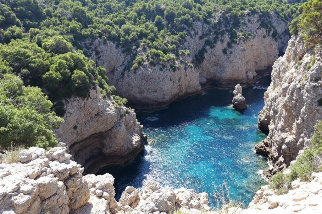 Falaises calcaires escarpées et baie bleue luxuriante