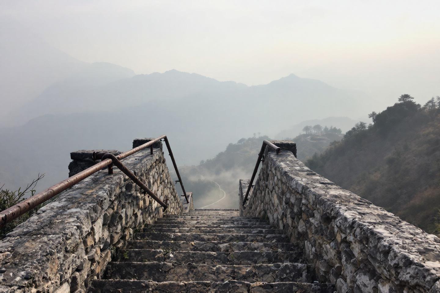 Escalier en pierre avec vue sur des montagnes brumeuses