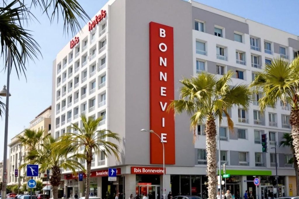 Bâtiment blanc et rouge avec palmiers en façade urbaine