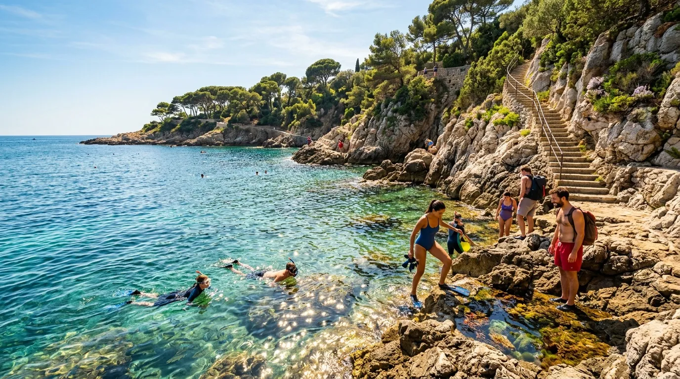 Plage rocheuse méditerranéenne avec baigneurs et escalier en pierre