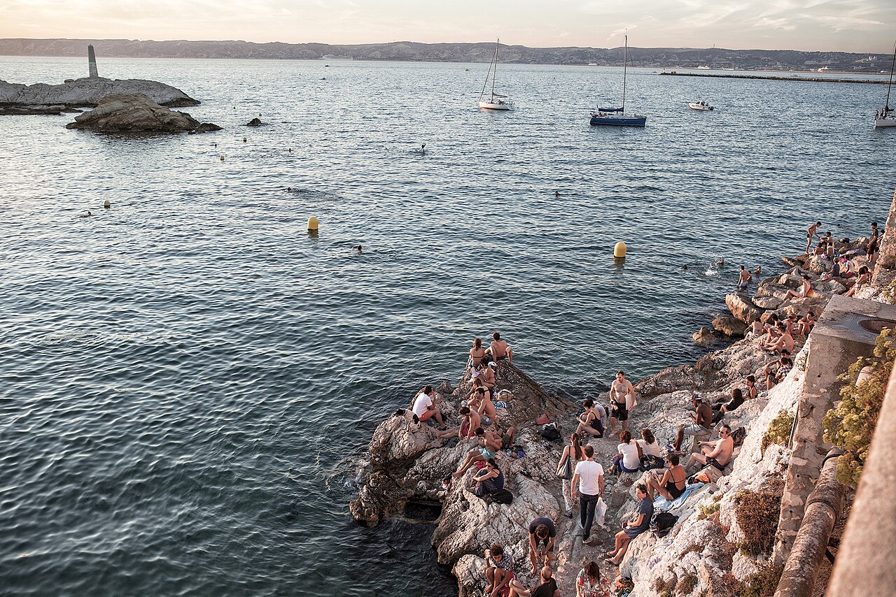 Vue sur la crique de Malmousque à Marseille en fin de journée, baigneurs sur les rochers